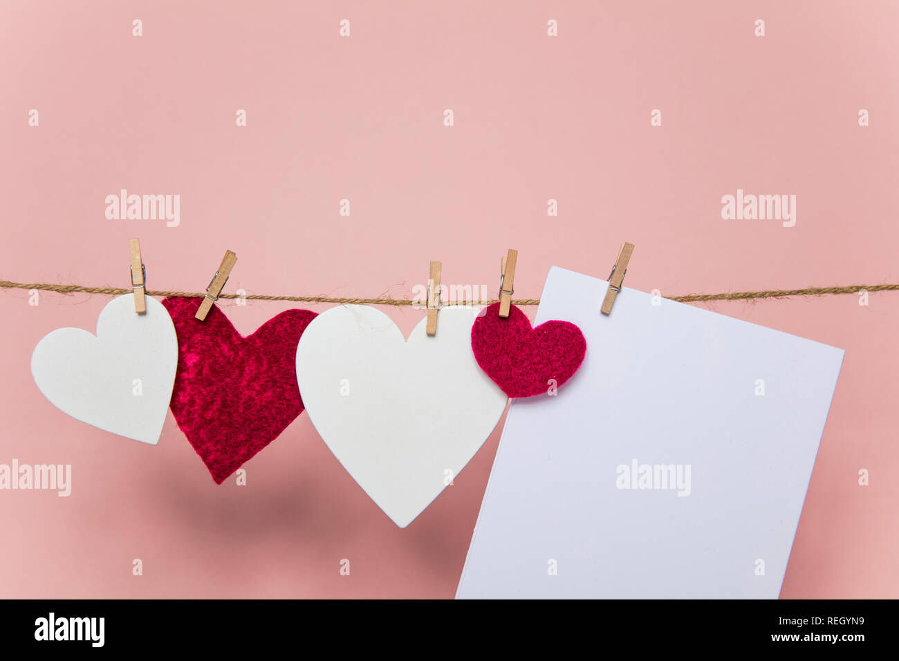 Love letter pegged to a line with red and white hearts. Stock Photo