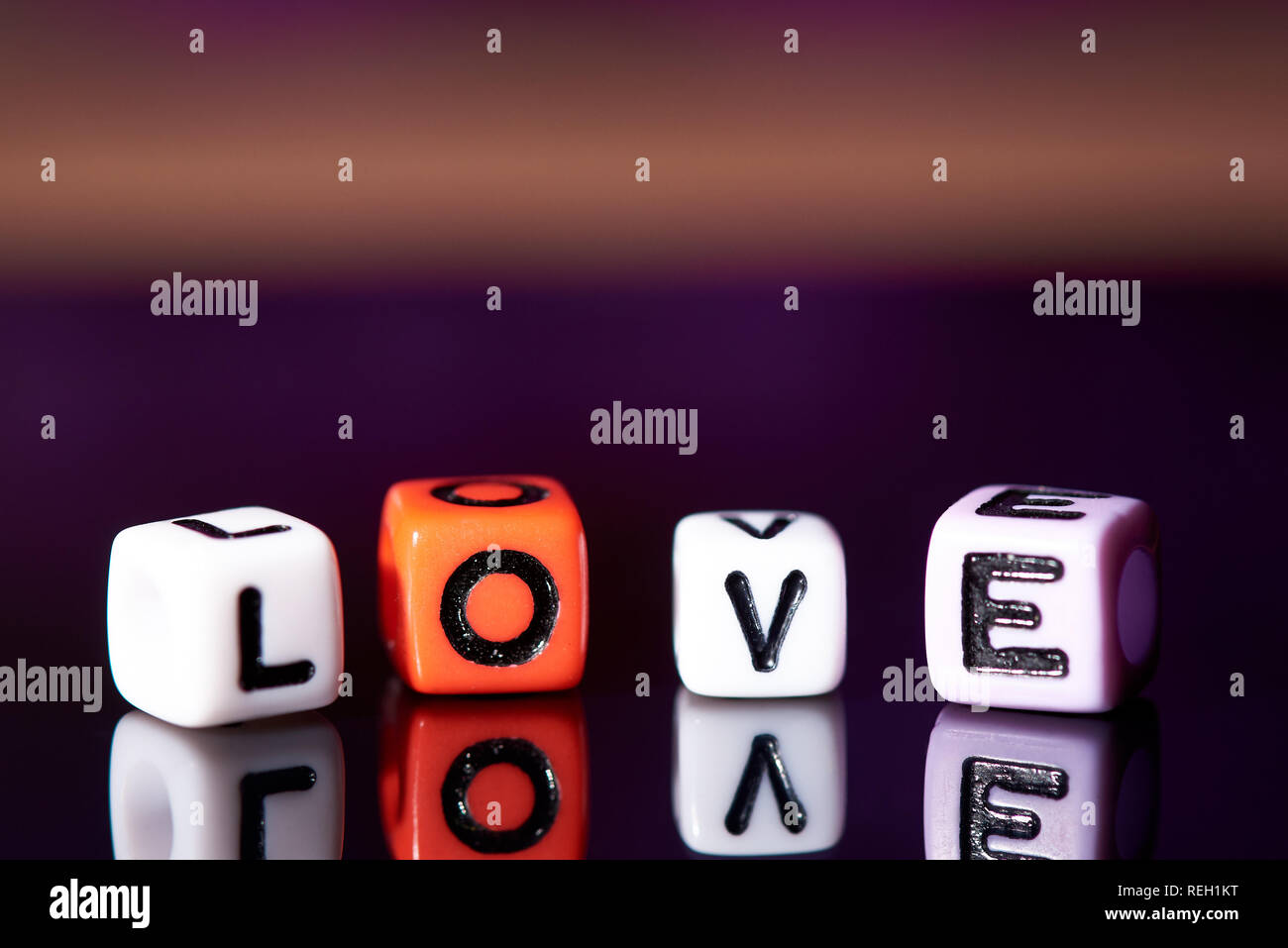 Word love from cubes with reflection on dark blurred background. Stock Photo