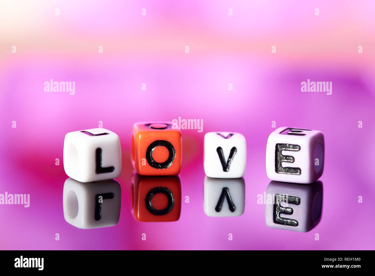 Word love  from cubes with reflection on bright blurred background. Stock Photo