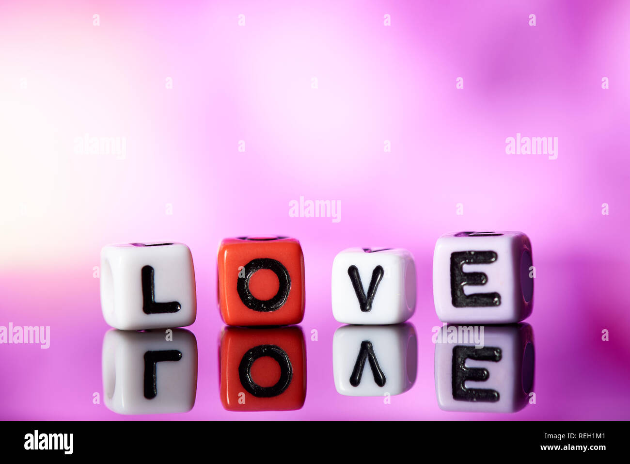 Word love  from cubes with reflection on bright blurred background. Stock Photo