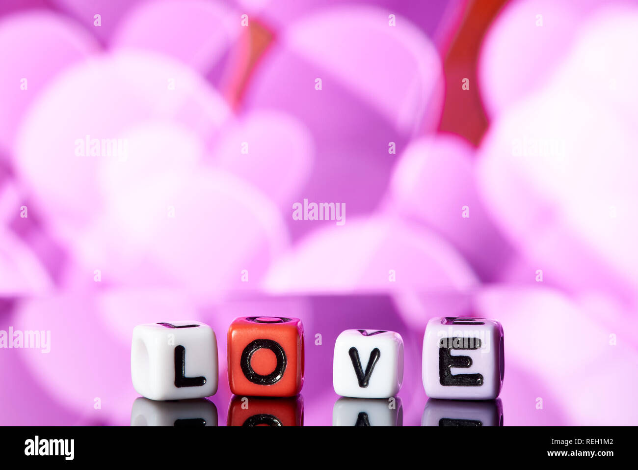 Word love  from cubes with reflection on bright blurred background. Stock Photo