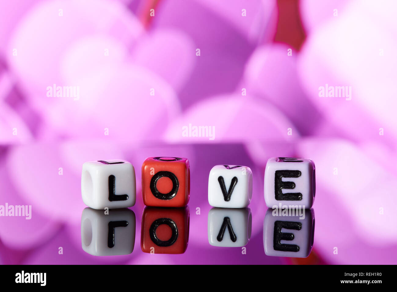 Word love  from cubes with reflection on bright blurred background. Stock Photo