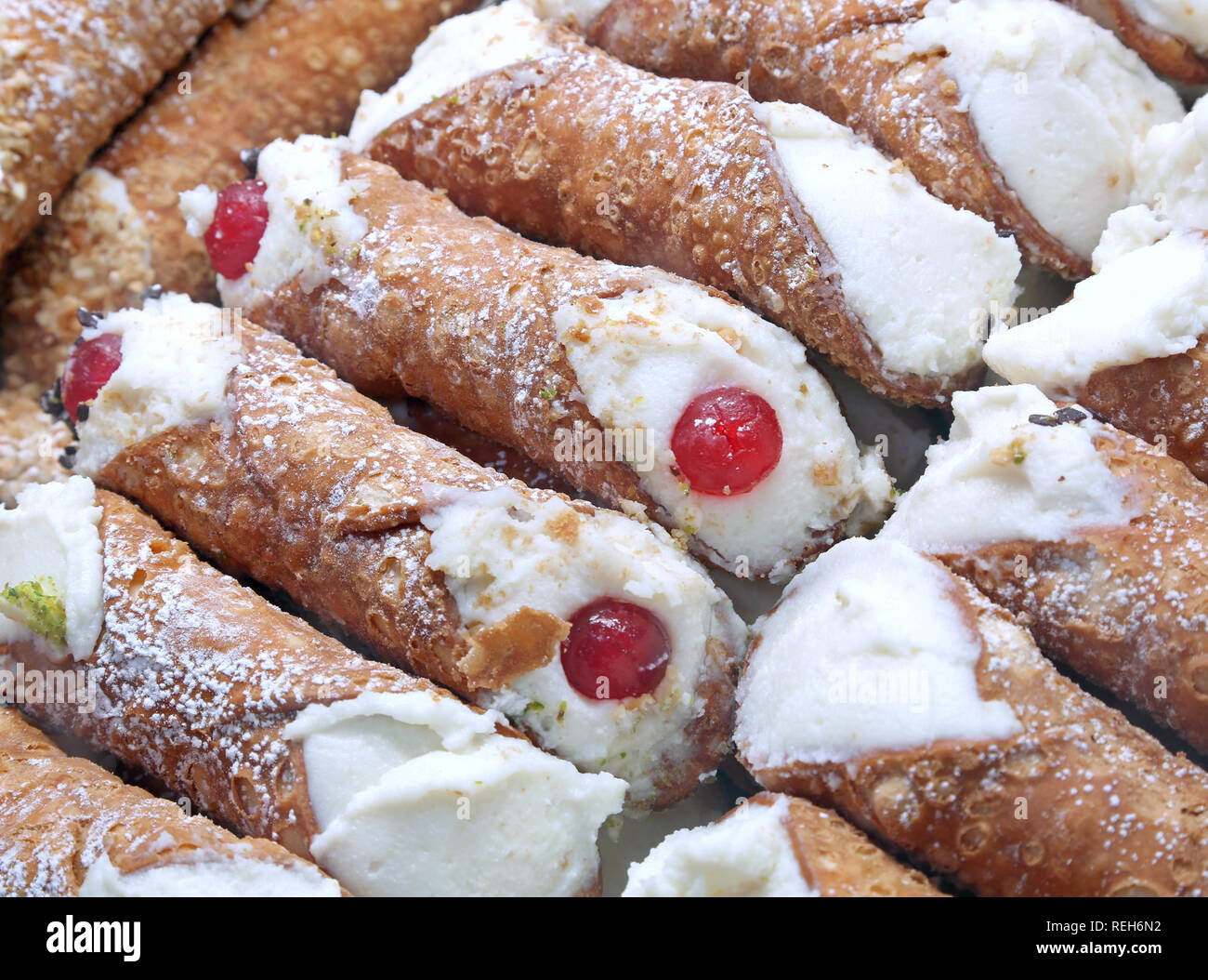 background of typical sweet food of Italy called CANNOLO SICILIANO with red candied cherries and cheese Stock Photo
