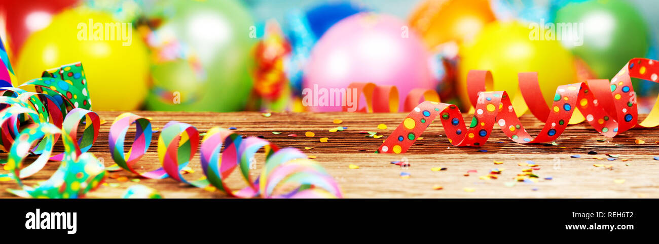 Panoramic party banner with colorful balloons, scattered confetti and twirled streamers Stock Photo