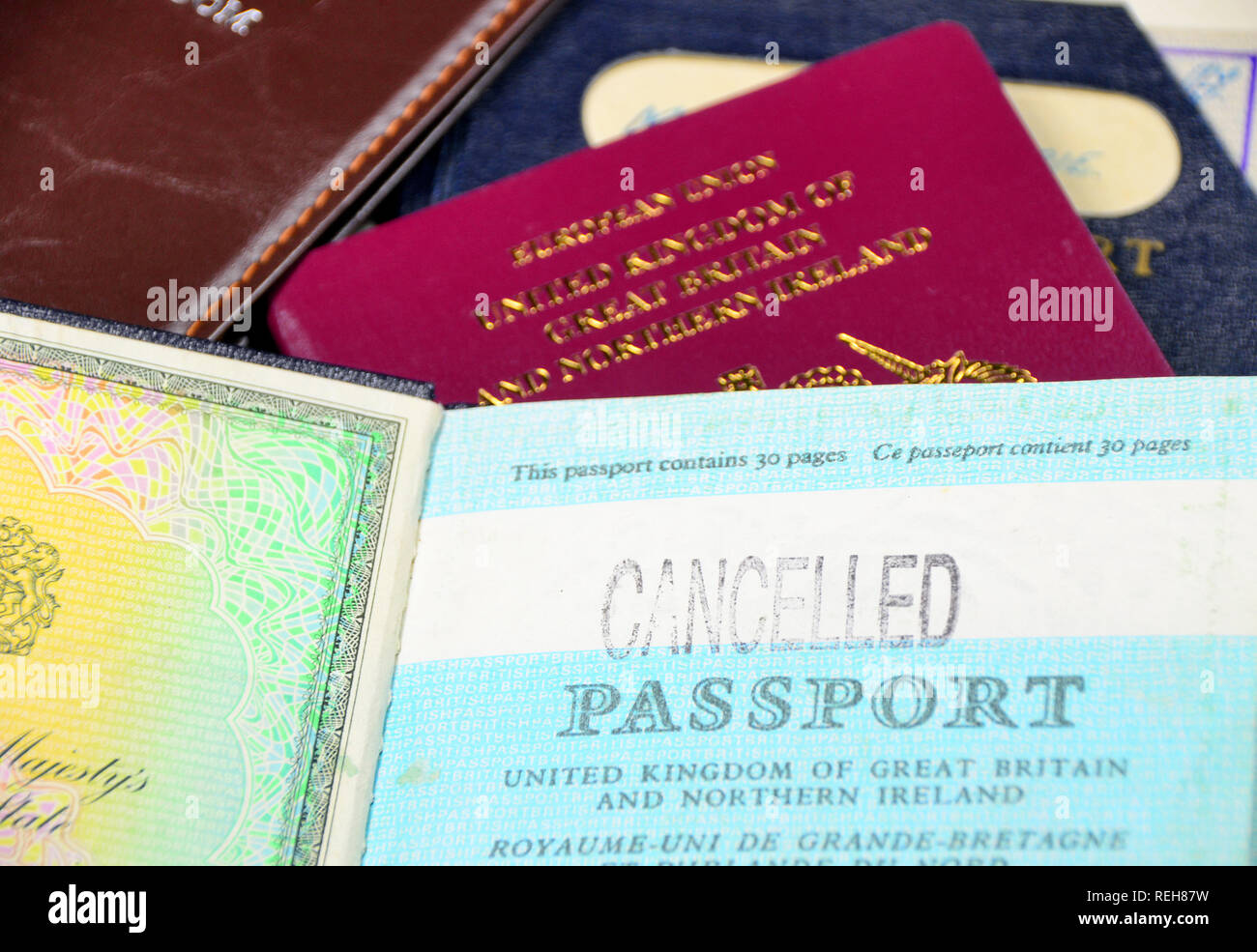 Old and new British  passports with an  opened page of an old cancelled passport. Stock Photo