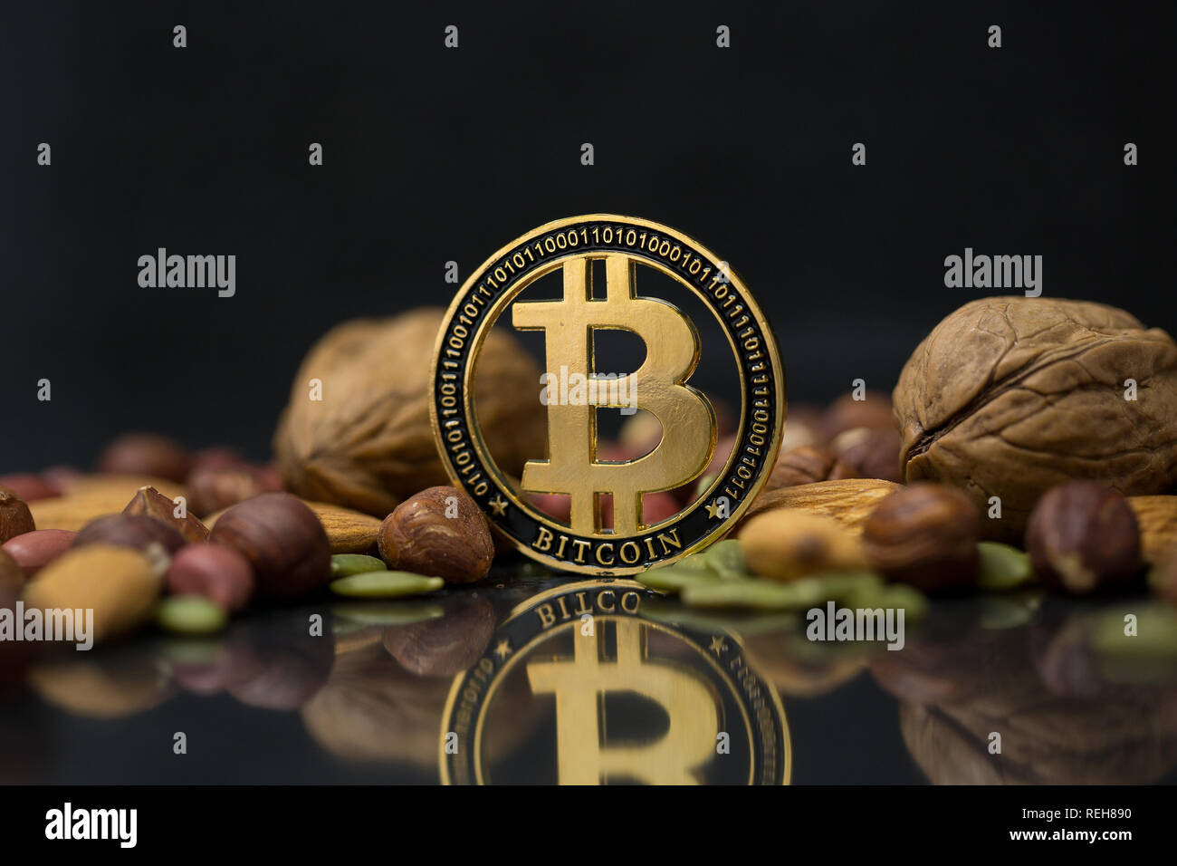 Bitcoin cryptocurrency physical coin surrounded with variety of nuts,  including walnuts, almonds, hazelnuts and pumpkin seeds in the black  background Stock Photo - Alamy