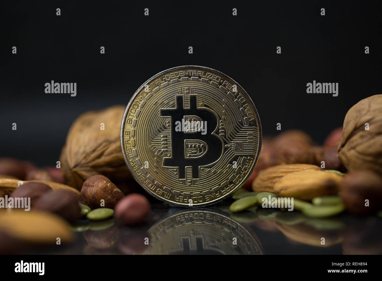 Bitcoin cryptocurrency physical coin surrounded with variety of nuts,  including walnuts, almonds, hazelnuts and pumpkin seeds in the black  background Stock Photo - Alamy