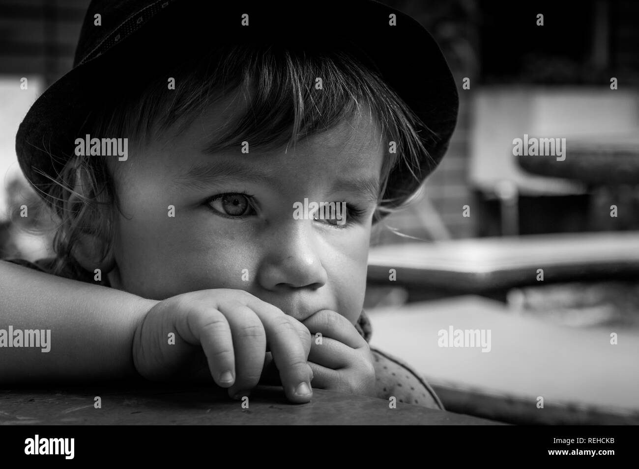 A black and white portrait of an adorable 2 years old baby boy wearing a hat. Stock Photo