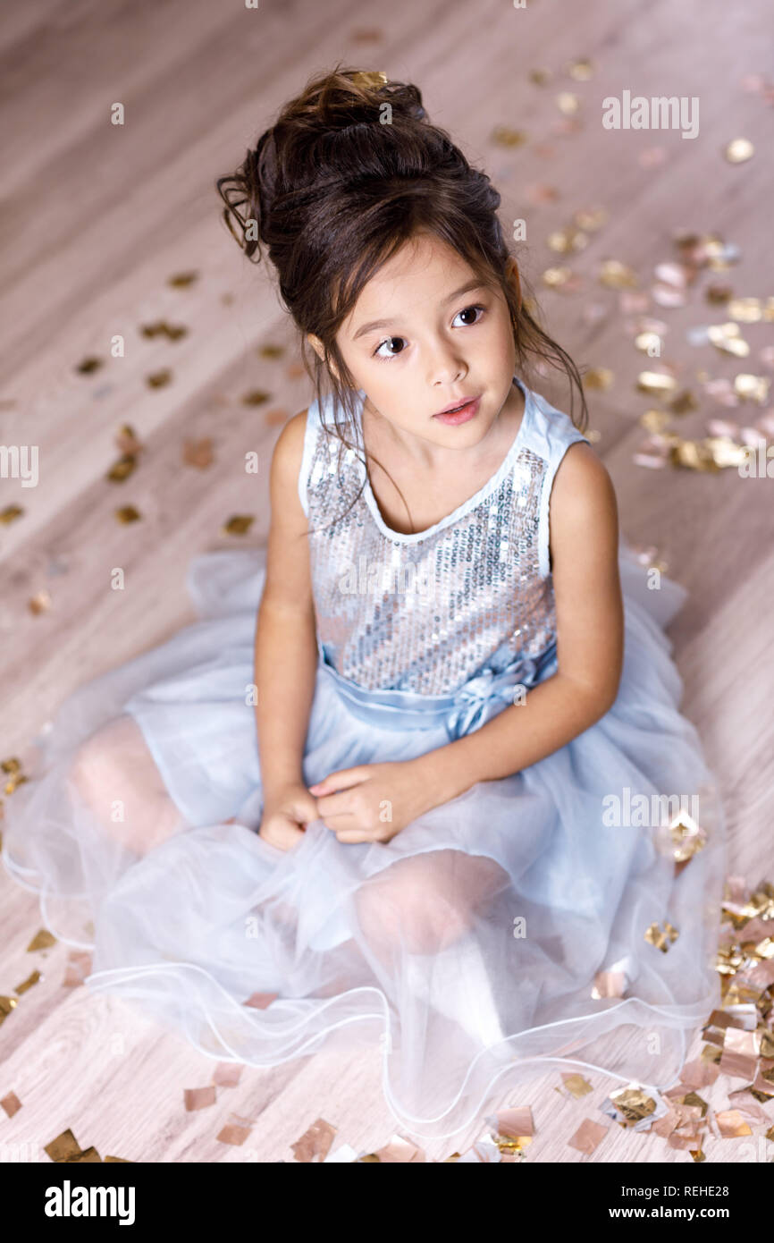 little girl in blue dress sitting on the floor with confetti Stock ...