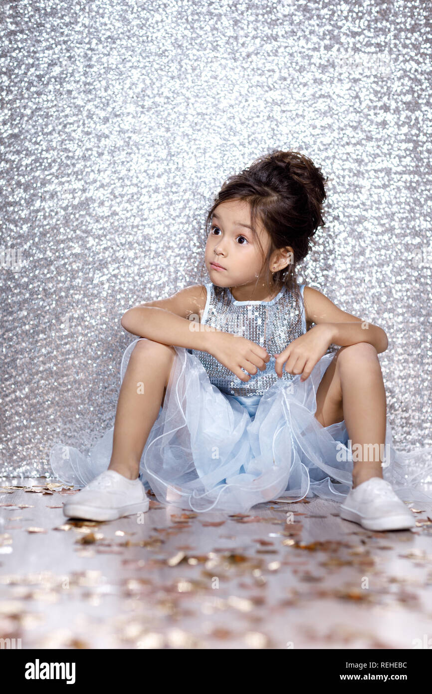 little child girl in dress sitting on the floor with confetti Stock