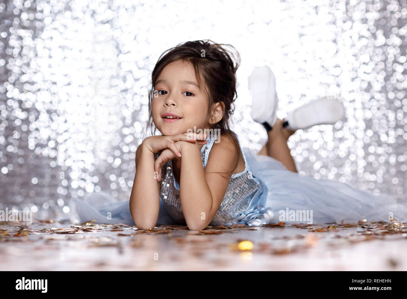 little girl in blue dress sitting on the floor with confetti Stock ...