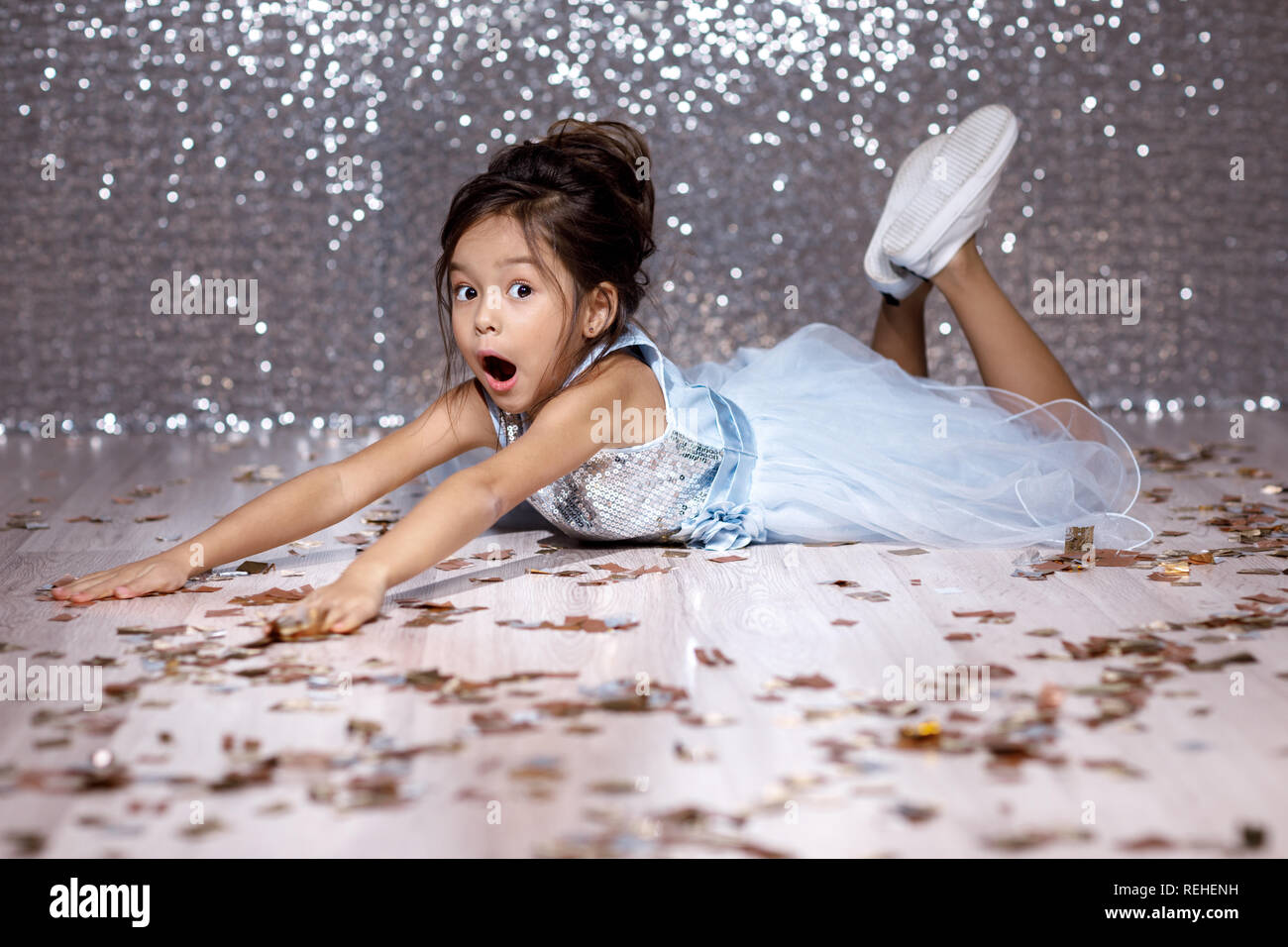 little girl in blue dress sitting on the floor with confetti Stock ...