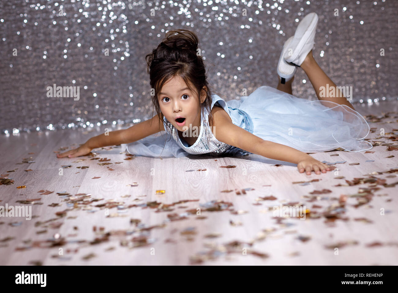 little girl in blue dress sitting on the floor with confetti Stock ...