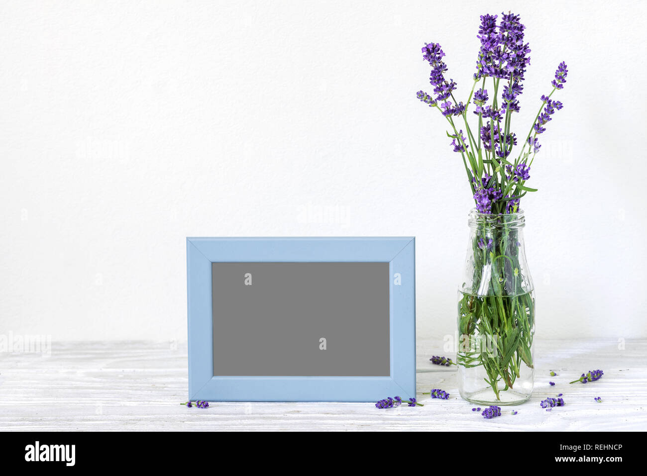 blank photo frame with a beautiful bouquet of lavender flowers. holiday or wedding background. still life Stock Photo