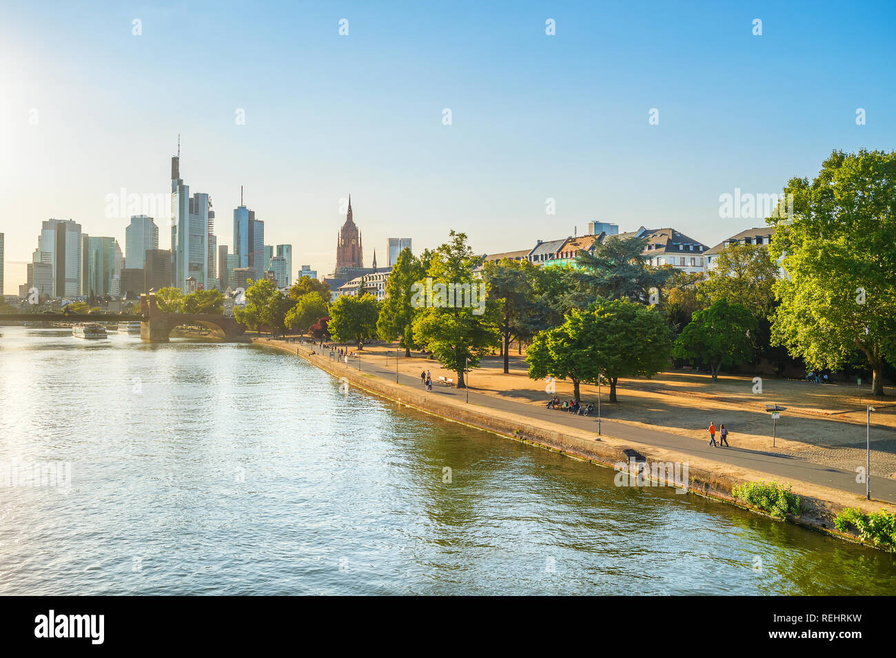 Evening sunshine over Main river embankment, modern city skyline in ...