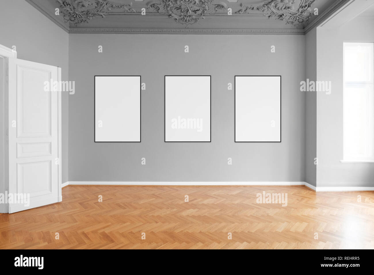 empty room with three blank picture frames hanging on wall in apartment Stock Photo