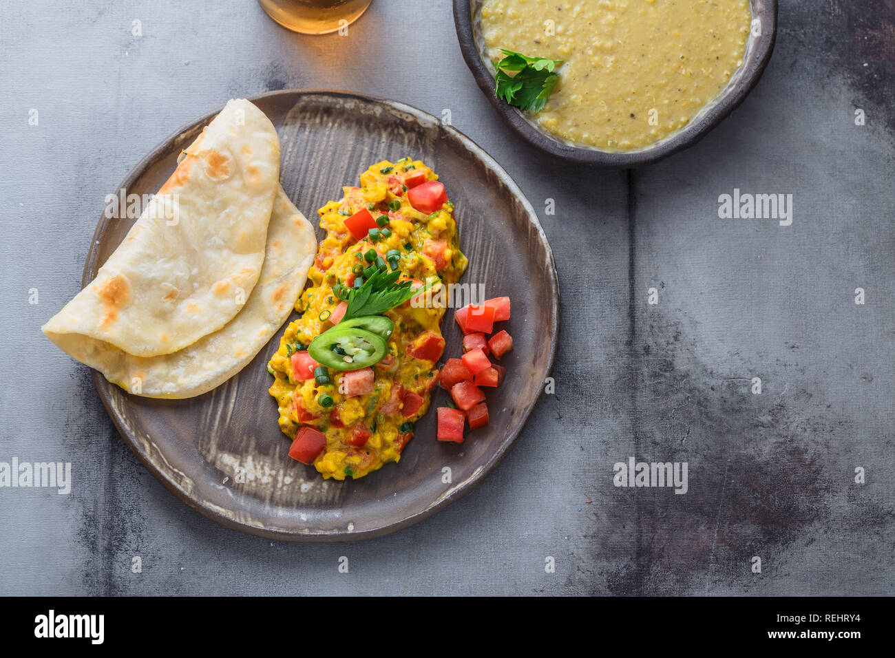 Indian Style scrambled eggs Akuri with paratha, dahl and ice tea, copy space Stock Photo