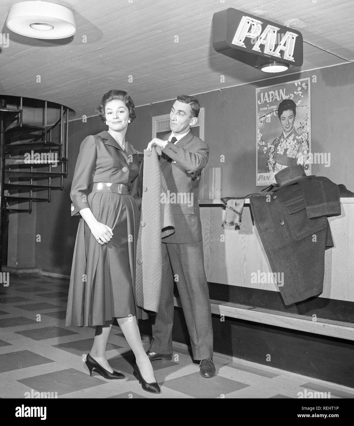 Couple in the 1950s. A young couple in an airport, ready for their holiday trip with Pan American Airlines. He is a gentleman and helps her with her coat.  Sweden 1950s. Photo Kristoffersson Ref CB15-12 Stock Photo