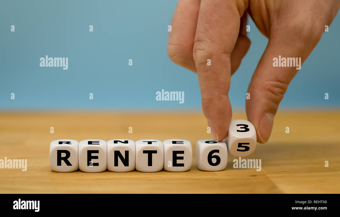Retirement with 65 or 63? Hand is turning a dice and changes the expression 'Rente 65' to 'Rente 63' (german for retirement with 65 or retirement with Stock Photo