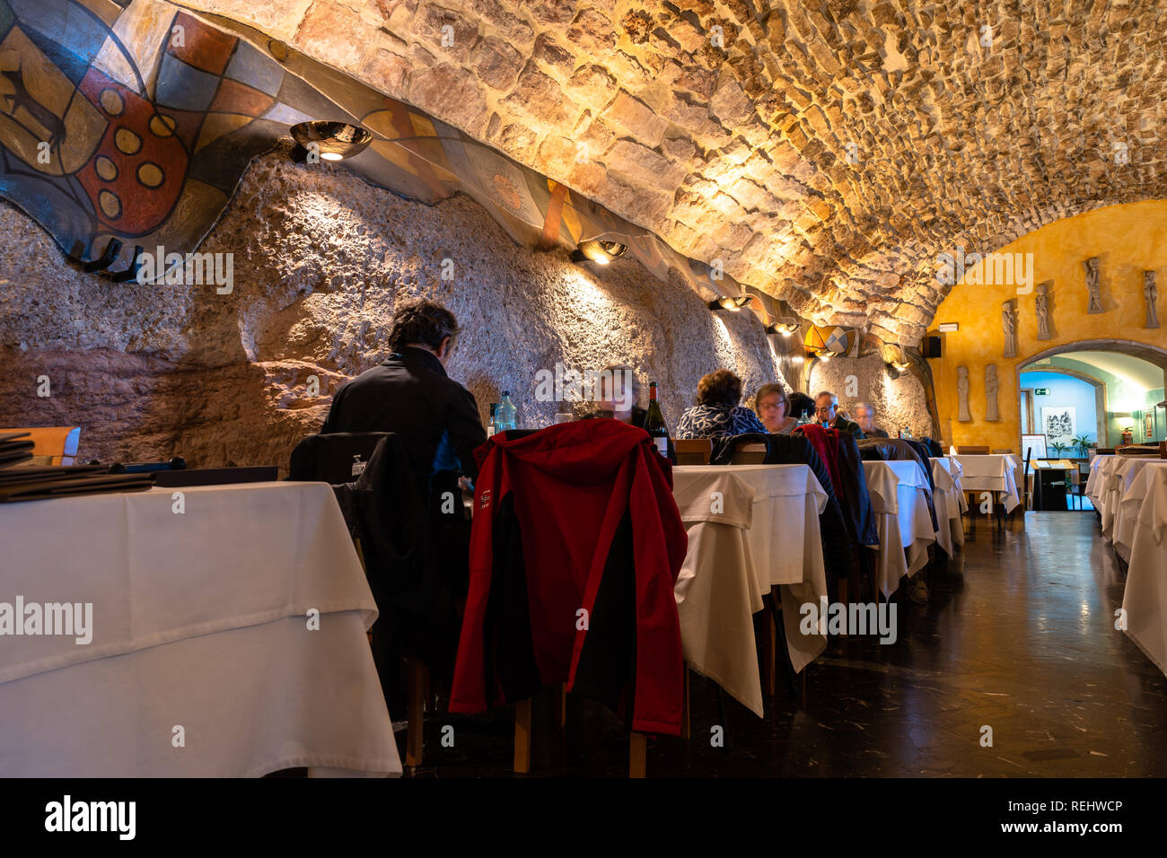 Tourists eating in the restaurant dining room of the Abat Cisneros hostel in Montserrat, stone roof, rustic roof, rustic room, rustic restaurant Barce Stock Photo