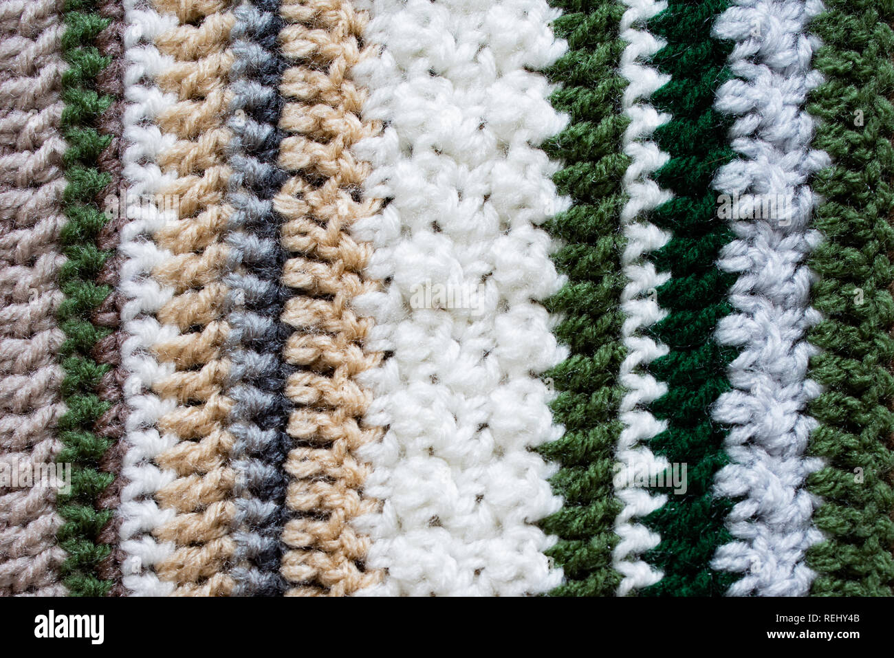 Closeup of an afghan crocheted from acrylic yarn with colors of the changing seasons, from winter into spring. Stock Photo