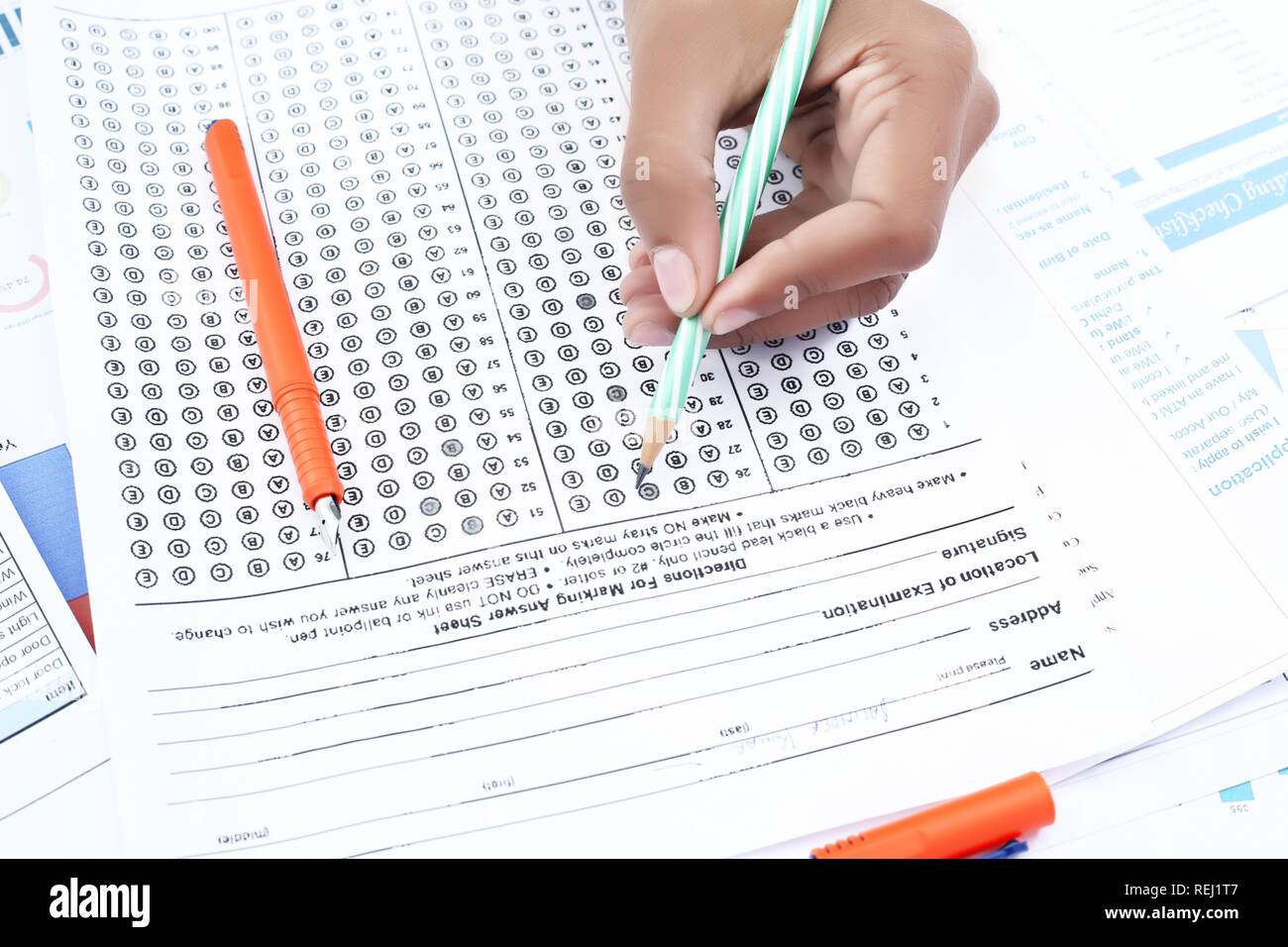 Man is filling omr sheet with pencil. Picture of pen on the omr sheet