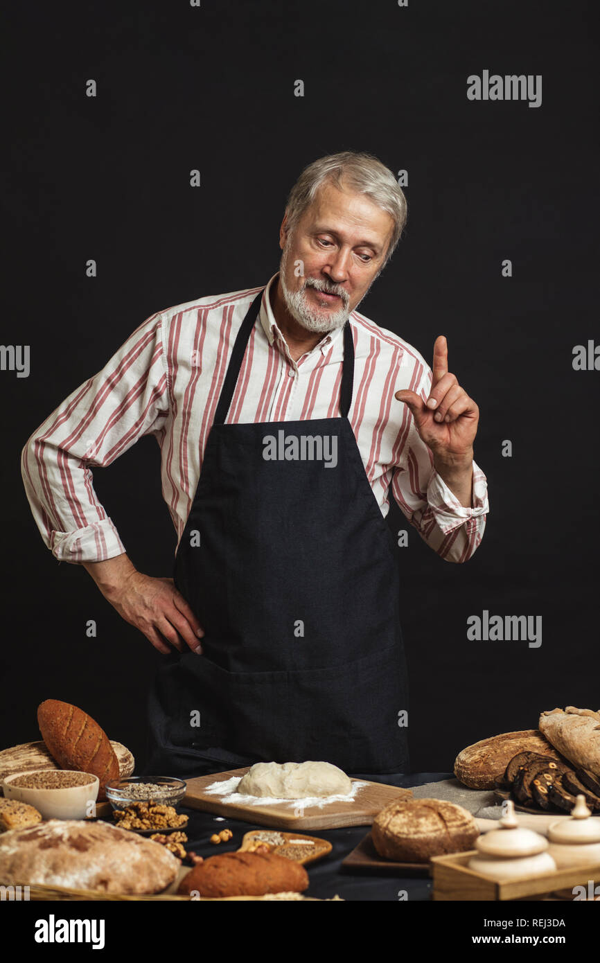Male senior chef isolated on black background Stock Photo