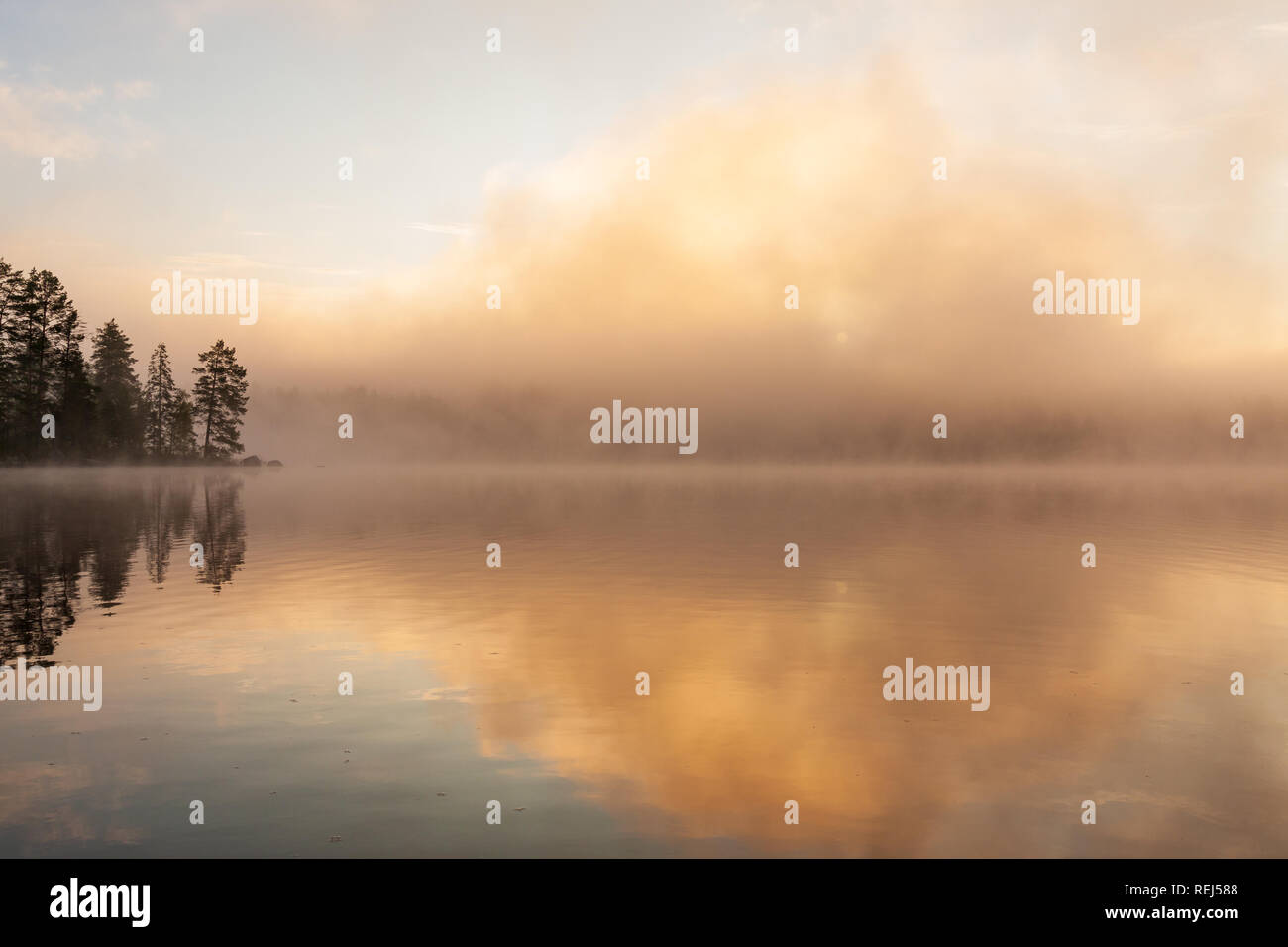 Fog rising from lake at sunrise waterscape Stock Photo
