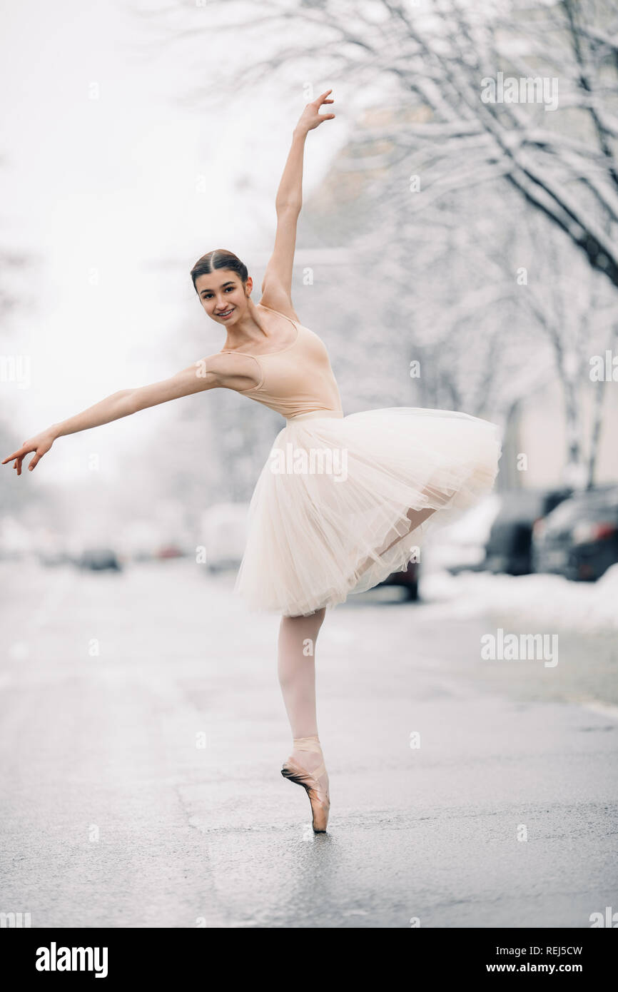 Beautiful ballerina in transparent skirt is dancing in the middle of the  snowy street Stock Photo - Alamy