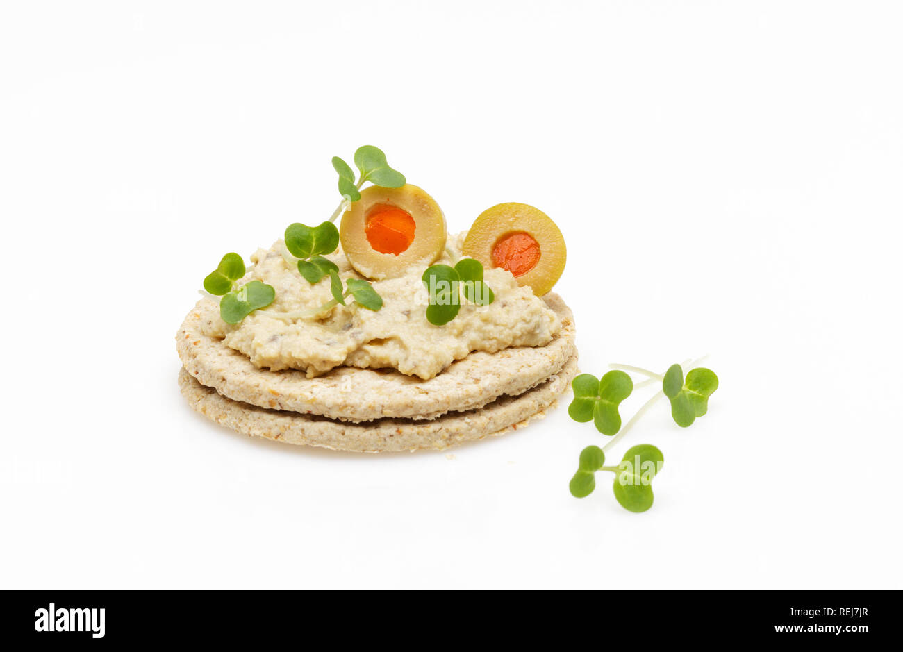 Gluten free oatcakes topped with hummus ,houmous  olives and cress on white background Stock Photo