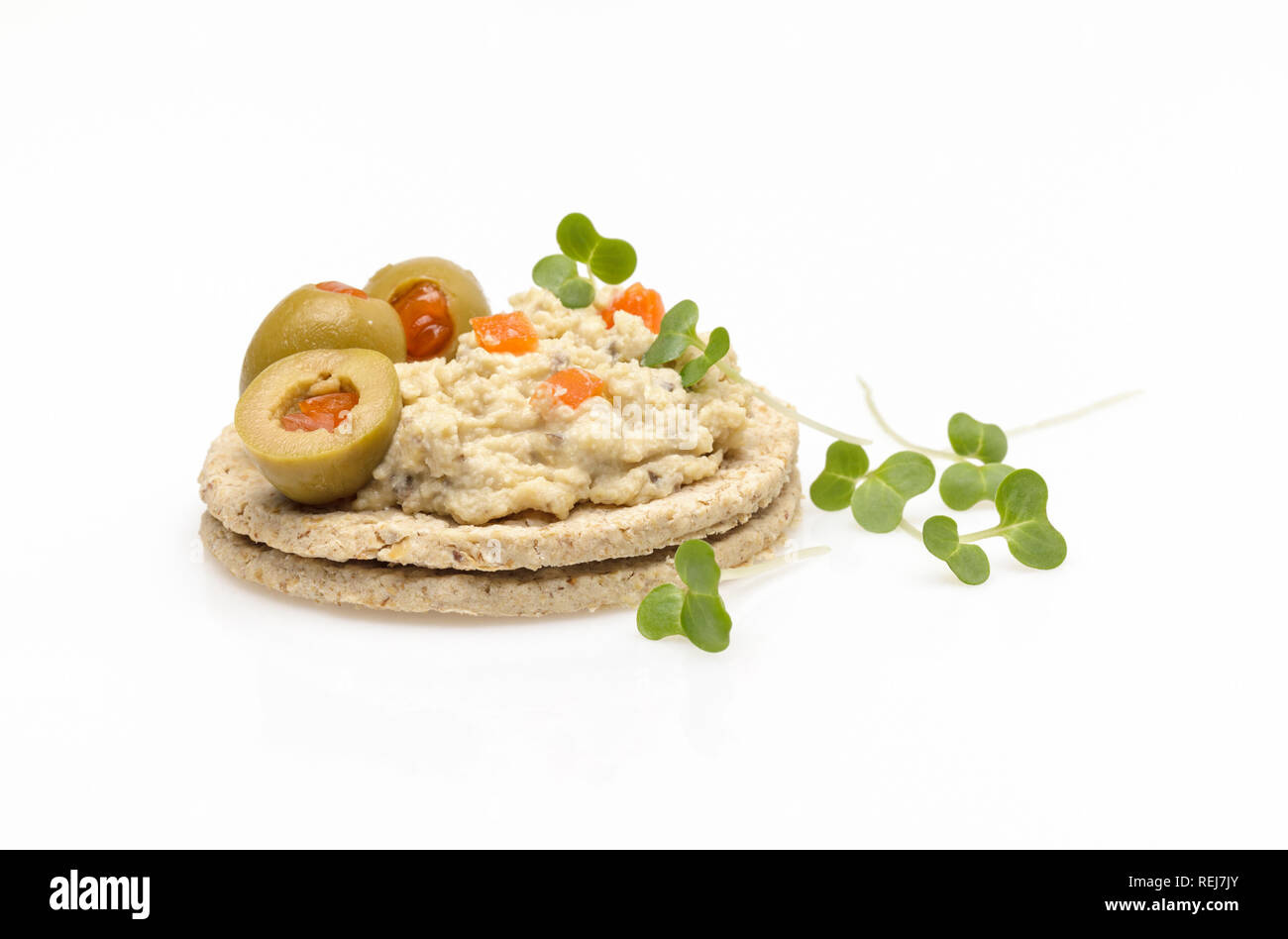 Gluten free oatcakes topped with hummus or houmous ,olives and cress Stock Photo