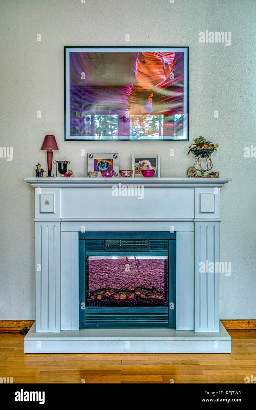 Electric Fire Place With Decorations On Top And A Framed Photo On
