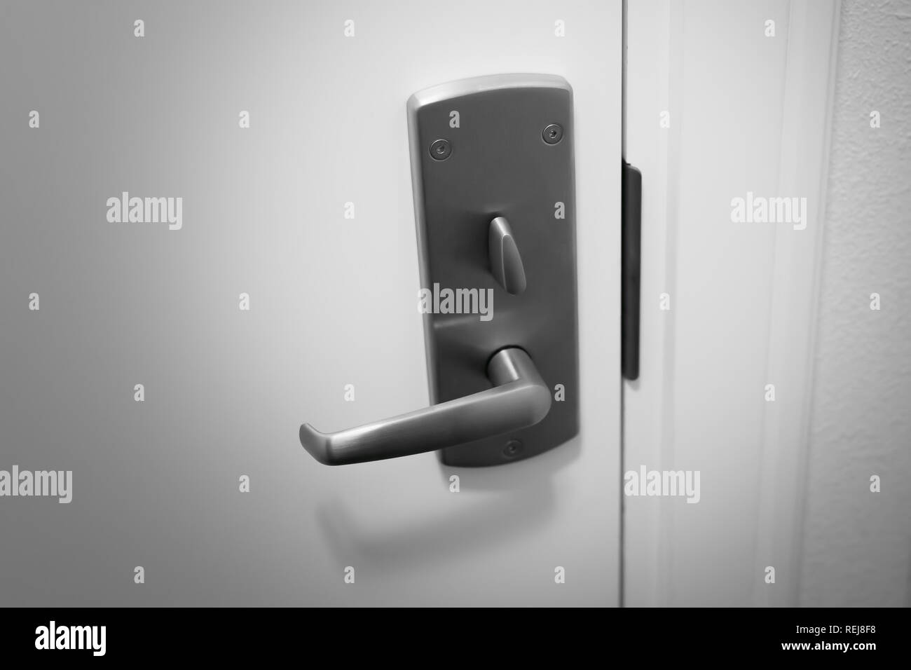 Modern metal door handle with a latch lock closeup. Blackwhite image