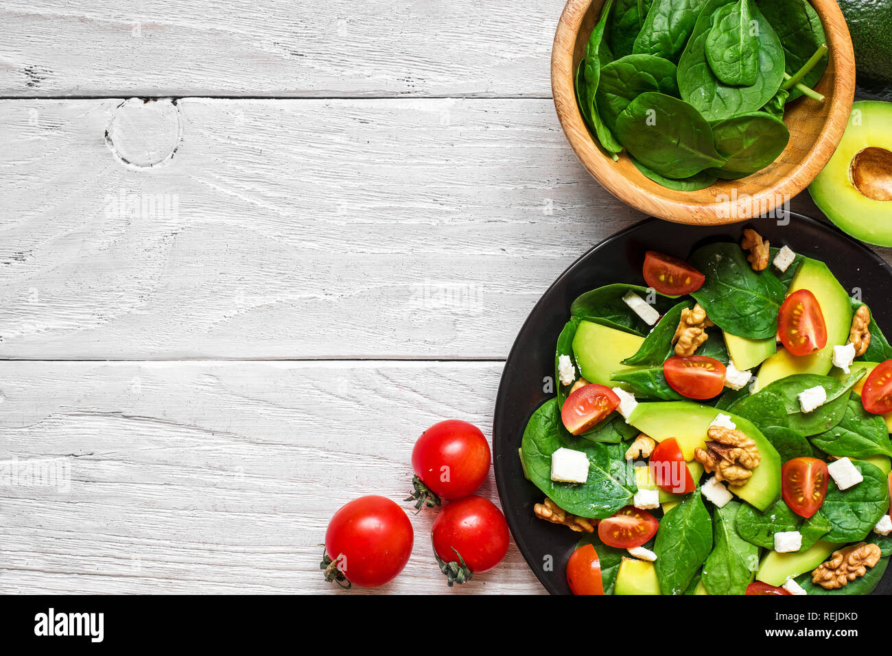 Fresh Salad With Avocado Spinach Tomatoes Cherry Feta Cheese And Walnuts In A Plate On White Wooden Table Top View With Copy Space Healthy Food Stock Photo Alamy