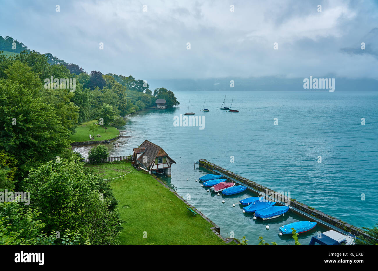 Landscape of Thun Lake on a rainy and foggy day. Taken in Spiez, Swiss Alps, Switzerland Stock Photo