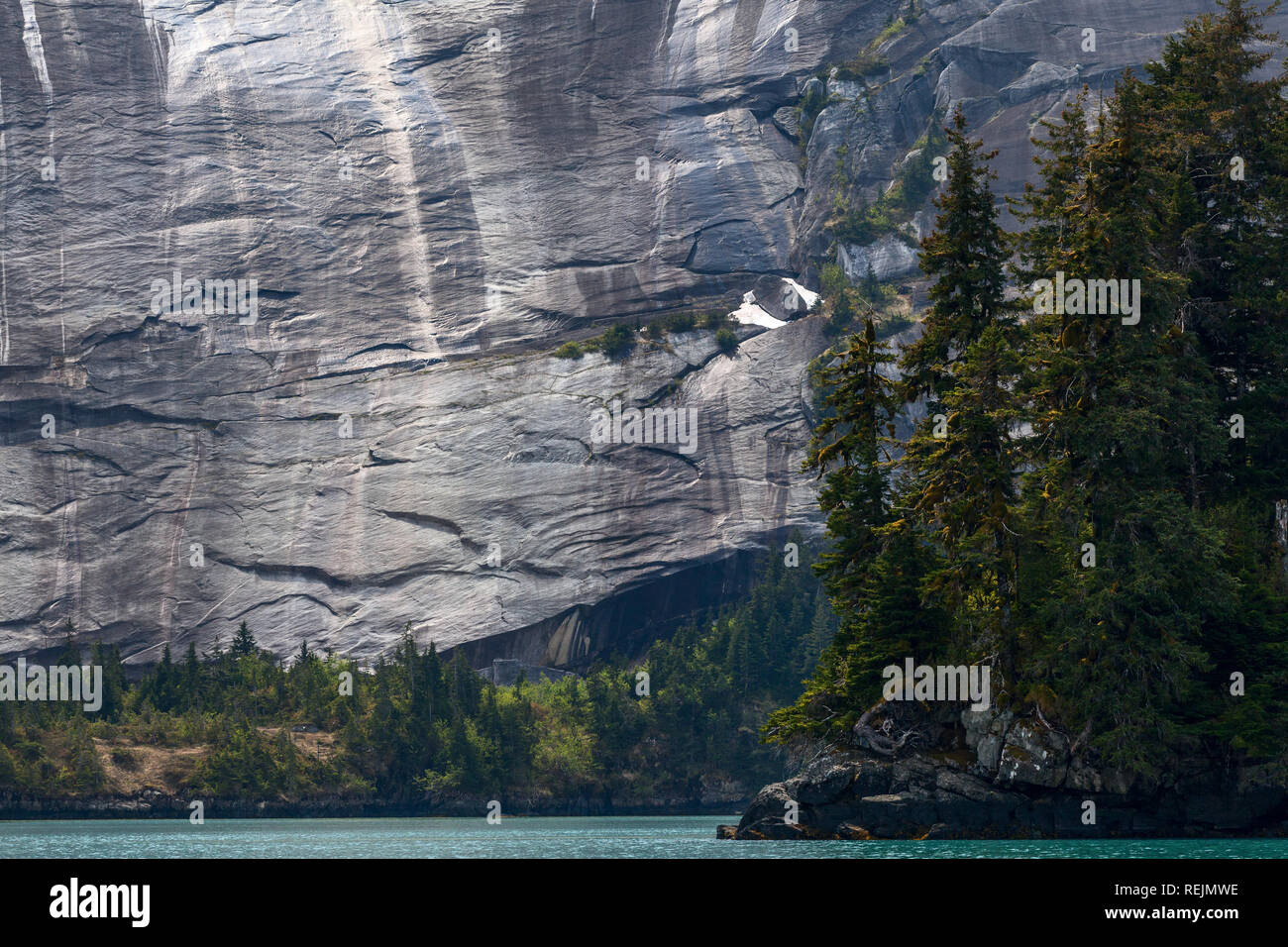 A shear wall of granite dominates the landscape of Greystone Bay, Prince William Sound, Alaska Stock Photo