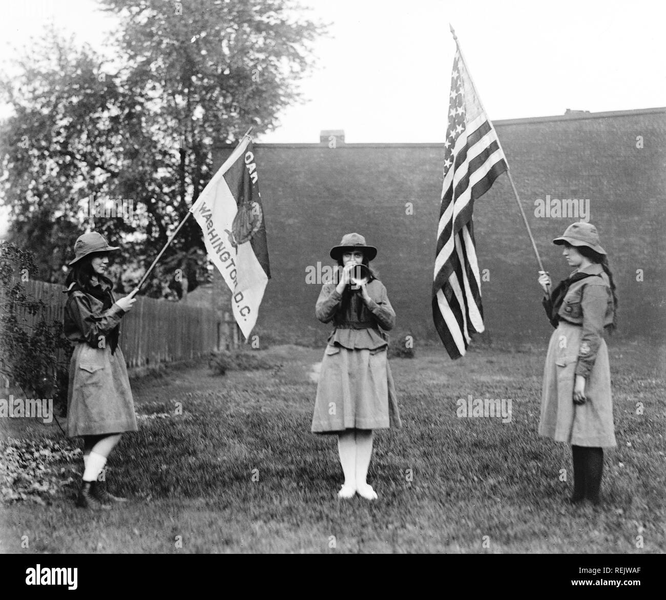 Three Girl Scouts, Two Holding Flags and one Playing Trumpet, Washington DC, USA, National Photo Company, 1920 Stock Photo