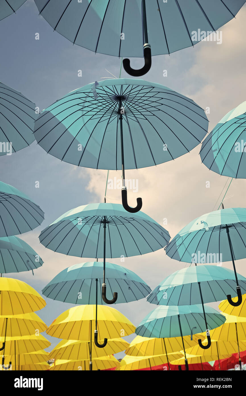 Outdoor art design and decor. Umbrellas float in sky on sunny day. Umbrella sky project installation. Holiday and festival celebration. Shade and protection. Stock Photo