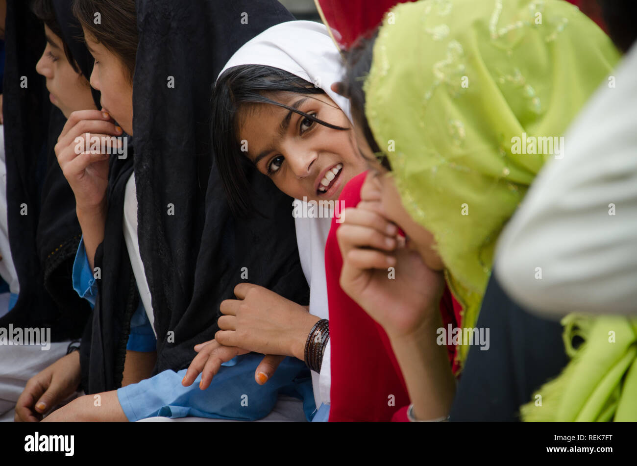 A school girl peeks at the camera in a scholl in KPK Pakistan Stock Photo