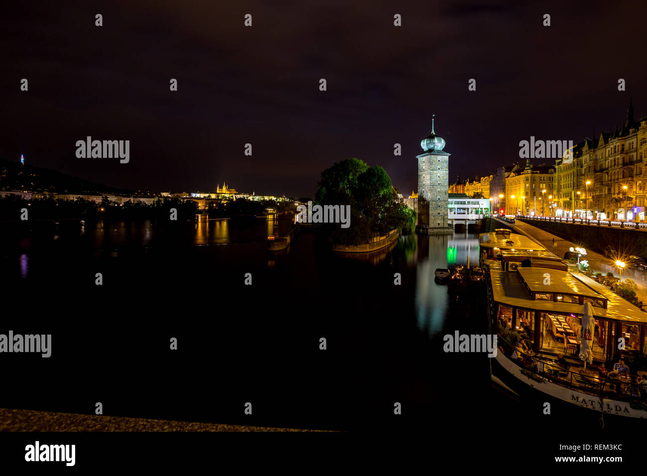 PRAGUE, CZECH REPUBLIC - AUGUST 28, 2015: People eat in floating boat restaurants at night, Vltava river, Prague, capital of Czech Republic in summer. Stock Photo