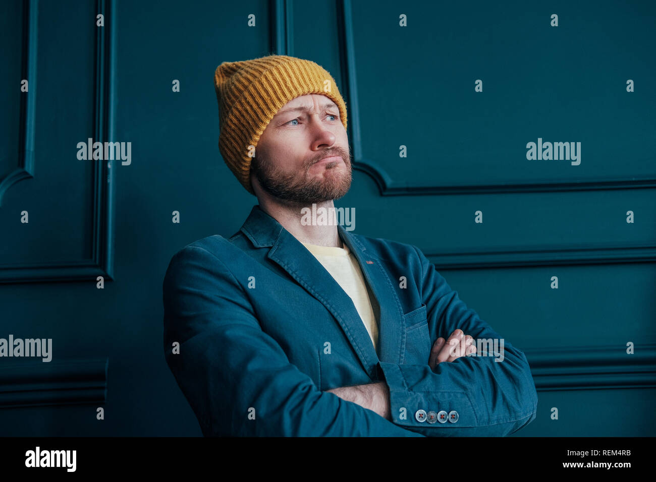 Attractive adult bearded angry man hipster in yellow hat looks at ...