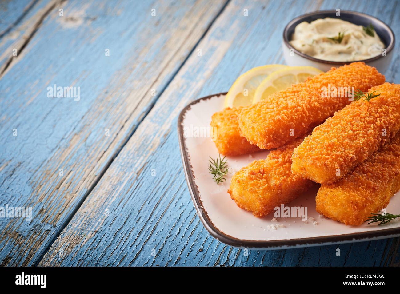 Tasty savory snack of crumbed fish sticks oven baked to a crisp served