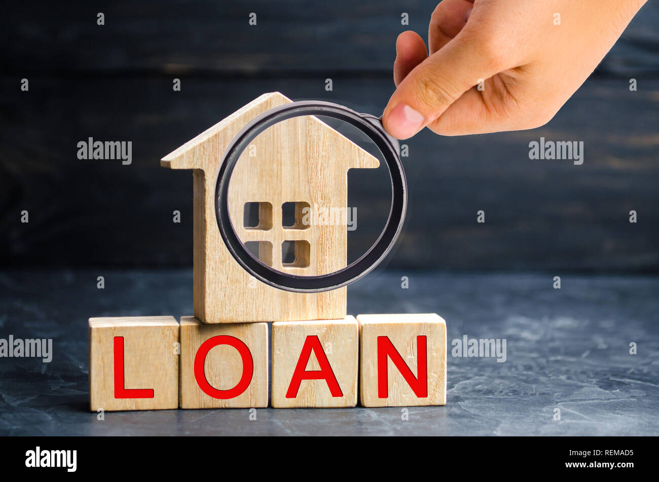 Model of the house and the inscription 'Loan'. Buying a home in debt. Family investment in real estate and risk management concept. Loan for a mortgag Stock Photo