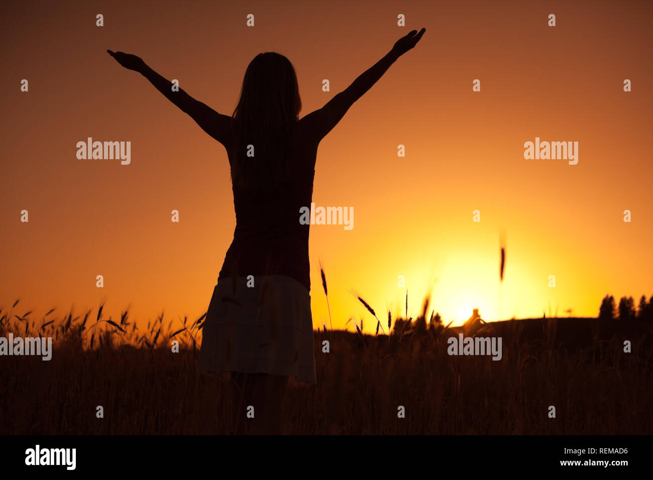 Silhouette of woman enjoying sunset Stock Photo - Alamy