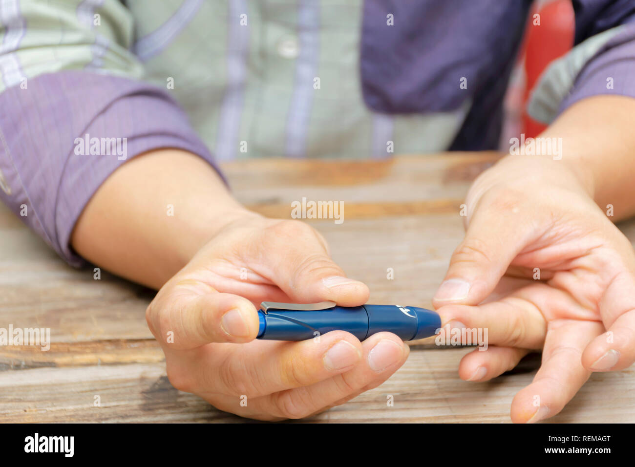 Man taking blood sample with lancet pen. Diabetes concept. Medicine