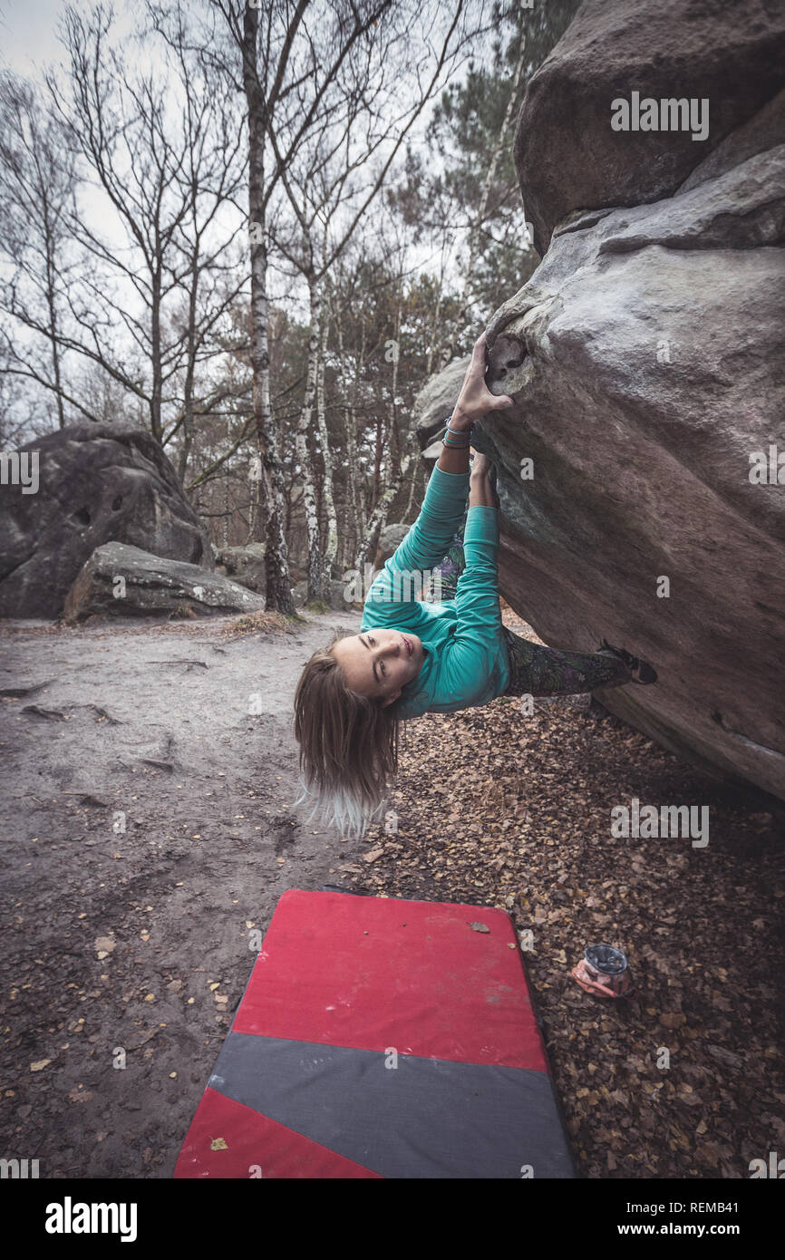 Boulderer Zofia Reych climbing in the forest of Fontainebleau, France. Stock Photo