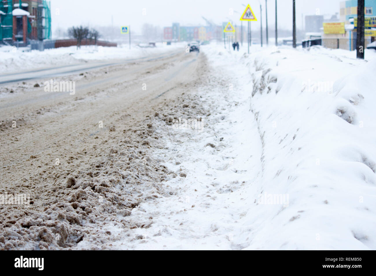 problem after snowfall - snow on the city road, snow porridge Stock Photo