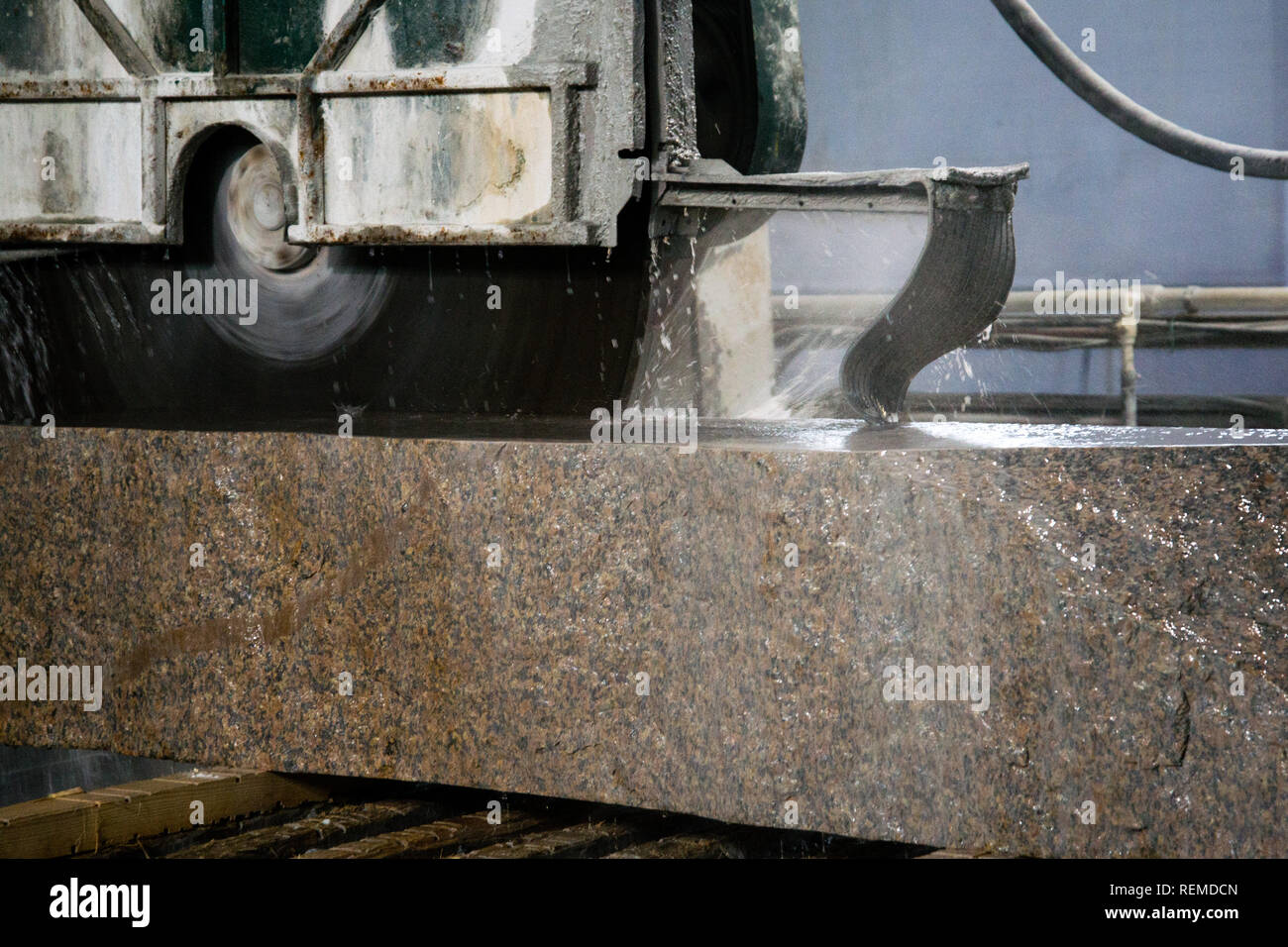 Granite processing in manufacturing. Cutting granite slab with a
