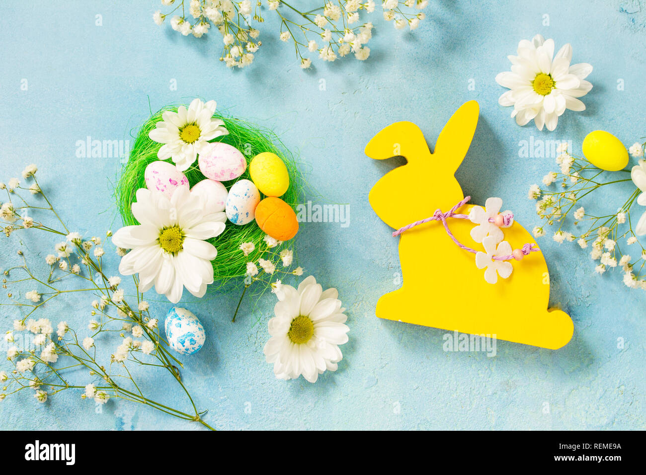 Easter background Card. Easter eggs cute bunny with Easter eggs and spring flowers. Top view flat lay background. Stock Photo