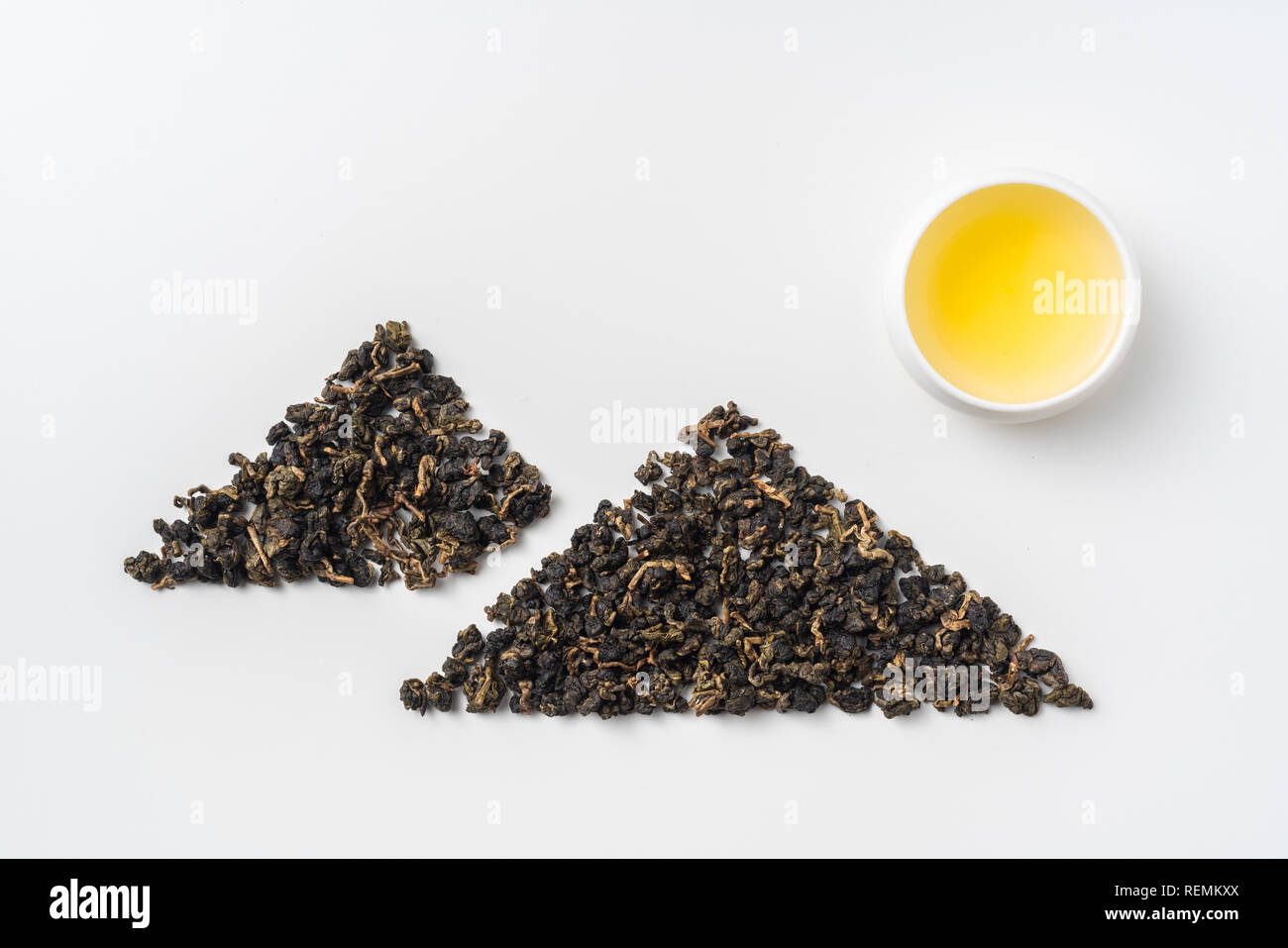 Asia culture and design concept - fresh taiwan oolong tea and cup with mountain shape made by dry tea dust Stock Photo
